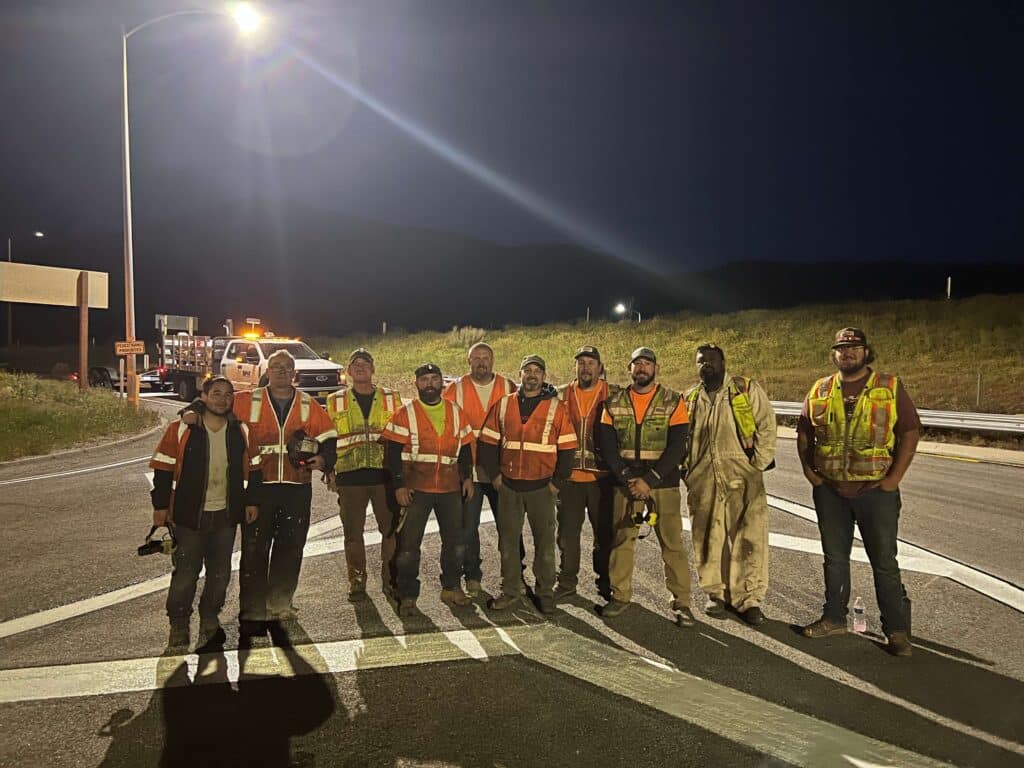 Field crew member applying pavement markings on roadway