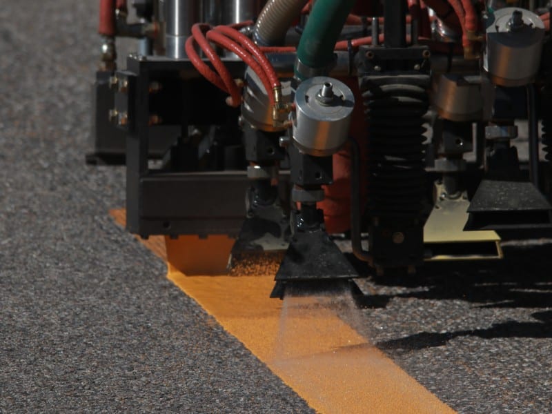 Close-up of pavement striping machinery in operation